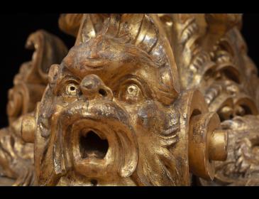 Large carved and gilded wooden sculpture depicting a siren supporting a vessel
